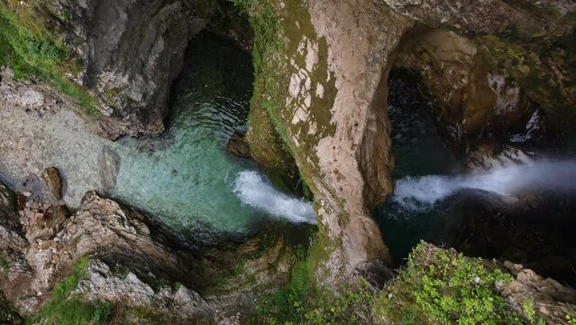 A man climbing the rocks of the waterfall in Uj&euml;vara e Peshtur&euml;s Albania. Top down drone shot.