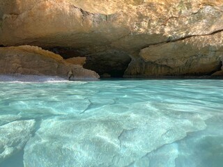 Blue sea water in secluded rocky cave. Beautiful clear aquamarine water in paradise lagoon.