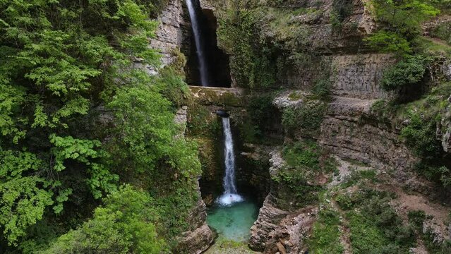 A man swimming in the Uj&euml;vara e Peshtur&euml;s waterfall in Albania.