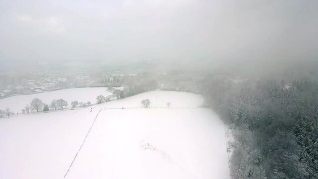 Snowy Winterberg Schwelm Droneshot back through clouds