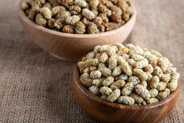 Bowl full of dried mulberry on a fabric background
