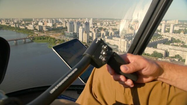 Pilot of the helicopter sits inside the cockpit controls the direction of piloting against the skyline of the city.