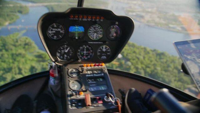 Robinson R44 helicopter control panel. Helicopter flying over the city of Kiev, view from the window of the helicopter.