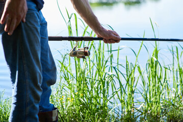 Close up hands holding a spinning . By the river. Fisherman.