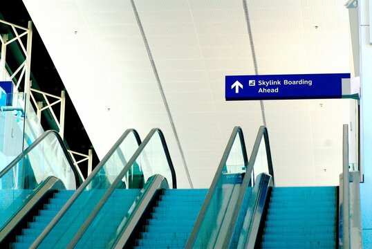 Beautiful shot of an escalator with a Skylink Boarding Ahead sign at an airport