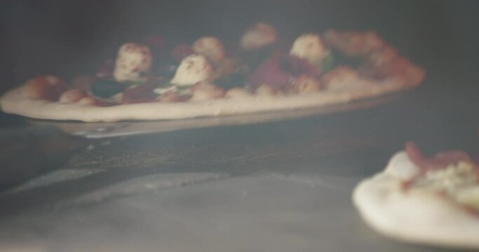 Cooking two fresh pizzas in a hot wood fired oven