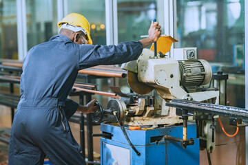 African man worker working cutting steel pipes For use in specific tasks with intention in the steel factory