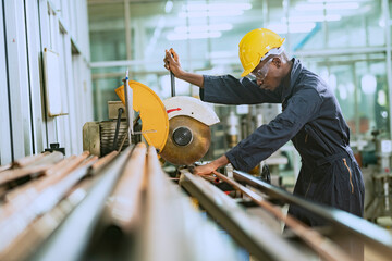 African man worker working cutting steel pipes For use in specific tasks with intention in the...