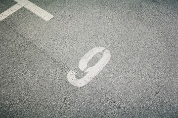 Shot of a parking space number 9 on the asphalt floor in paint
