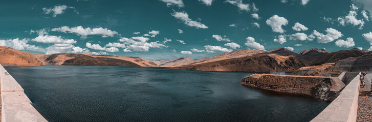 panoramico de 180 grados de una laguna y una represa con montañas nubes