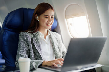 portrait of A successful asian businesswoman or female entrepreneur in formal suit in a plane sits...