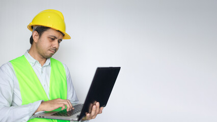 Male Asian construction worker working with laptop computer copy space
