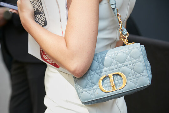 Woman with pale blue Christian Dior leather bag with golden logo on June 20, 2022 In Milan, Italy