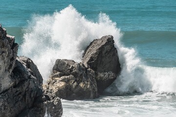 Closeup shot of ocean waves hitting the huge rocks in Australia