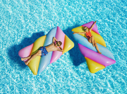 Funny children On Inflatable Swimming Mattress In Pool