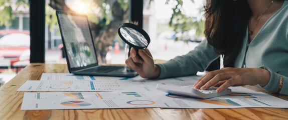 Tax inspector and financial auditor looking through magnifying glass, inspecting company financial...