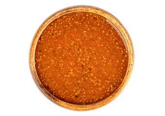 Top view of a wooden bowl full of Bavarian mustard on a white background.