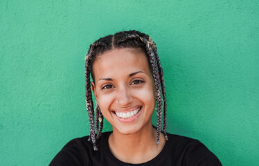 Happy latin woman with braided hair smiling on camera