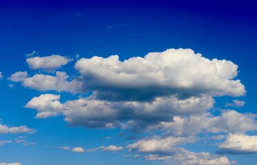 The fluffy cloudscape in the bright blue sky.
