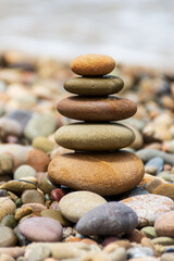 Fototapeta na wymiar Pyramid stones balance on the beach. Calm. Zen-like concept.