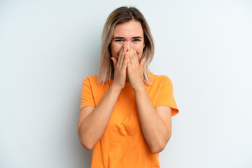 young adult pretty woman looking happy, cheerful, lucky and surprised covering mouth with both hands