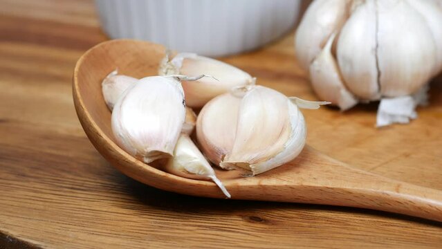 close up pf garlic on a wooden spoon 