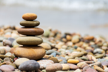 Fototapeta na wymiar Pyramid stones balance on the beach. Calm. Zen-like concept.