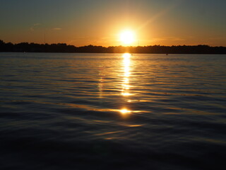 Obraz premium Lake Sunset Reflecting on Pontoon Boat
