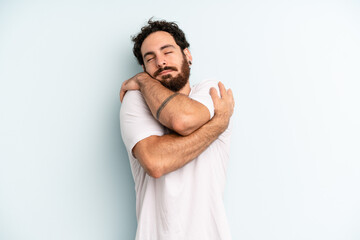 young adult bearded man feeling in love, smiling, cuddling and hugging self, staying single, being...