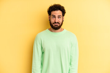 young adult bearded man looking goofy and funny with a silly cross-eyed expression, joking and...
