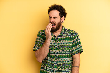 young adult bearded man yawning lazily early in the morning, waking and looking sleepy, tired and...