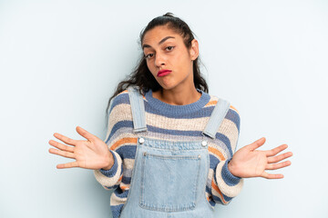 hispanic pretty woman feeling puzzled and confused, unsure about the correct answer or decision,...