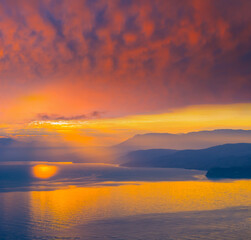 Fototapeta na wymiar sea bay with mountain coast at the dramatic sunset