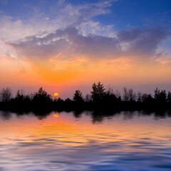 Fototapeta na wymiar dramatic sunset over small lake, quiet natural sunset background