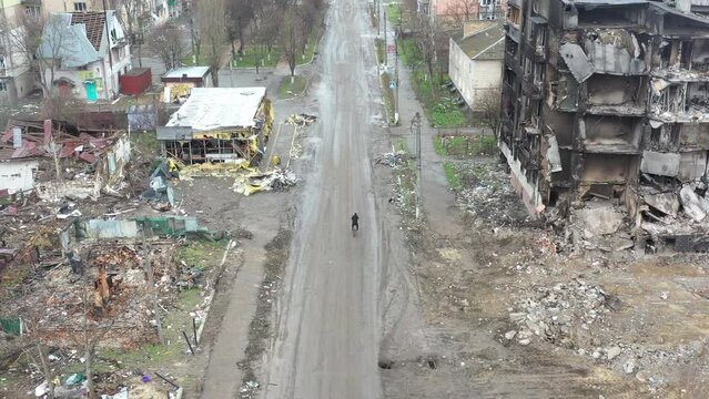 Cyclist riding in the middle of a russian-destroyed city