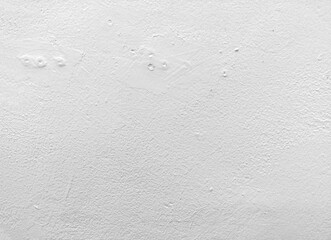 パテ埋めの痕のある白いペンキの塗り壁