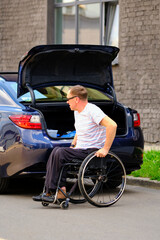 Naklejka premium person in a wheelchair near his car