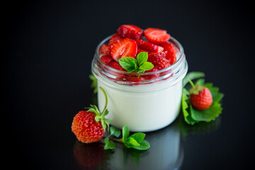 Sweet homemade yogurt with fresh ripe strawberries in a glass jar