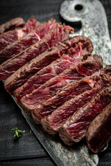 Barbecue dry aged wagyu porterhouse steak, grilled medium rare beef steak with spices served on old meat butcher. sliced. top view