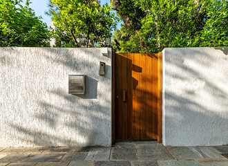 Contemporary house exterior entrance with a natural brown wood door, Athens, Greece.