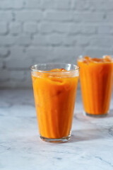 glasses of iced Thai tea on marble background