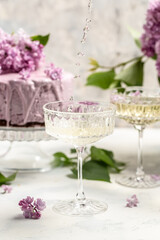 Delicious prosecco, champagne, wine with berry mousse cake bouquet of purple blooming lilacs, French cuisine, postcard, background