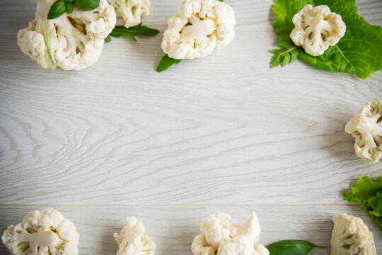 inflorescences of small cauliflower on a light wooden table