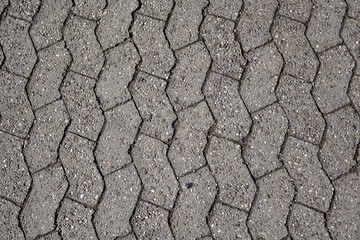 old concrete paver brick on a street surface. Made from concrete for road, path or driveways paving