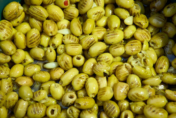 A pile of shiny Syrian green olives, full of oil. No kernels. Blurred background. Arabic style. The...