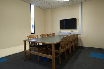 empty study room with TV, chairs, and table