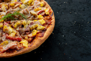 Margherita pizza on black stone background, top view. Margarita pizza with pineapple, and mozzarella cheese close-up.	
