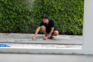 man working on explsed aggregate finish the front of the house