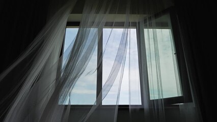 Wind blows from the window and flutters the curtains