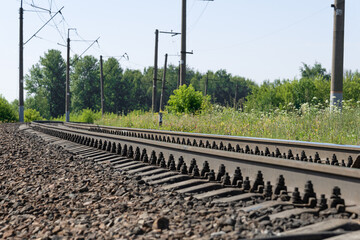 Metal rails of a railway train, road into the distance, railway station